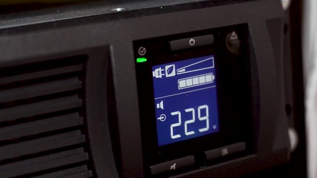 Closeup of digital display on uninterruptible power supply with automatic voltage stabilizer. Control panel with alarm module of uninterruptible power supply system ups in server room. Uninterruptible