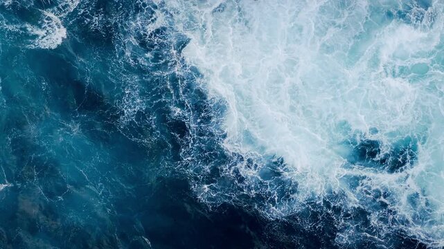 Aerial scene of deep blue ocean waves creating white foam pattern