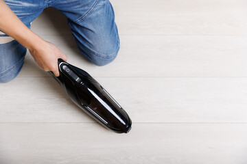 Housework and housekeeping concept - Man with vacuum cleaner floor at home