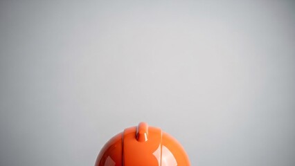 Orange plastic bottle cap on gray background with copy space