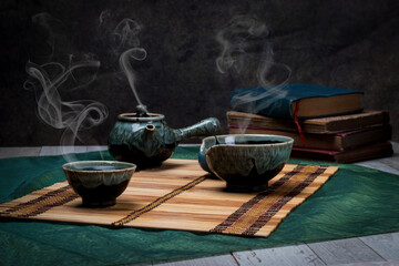 Steaming Tea Set with Ceramic Teapot and Cups on Bamboo Mat, Relaxing Still Life
