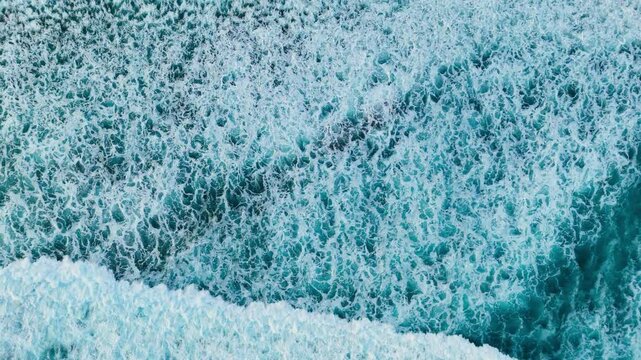 Aerial top down view powerful waves splashing white foam on stormy day, Drone shot of breaking surf with foam in Atlantic ocean