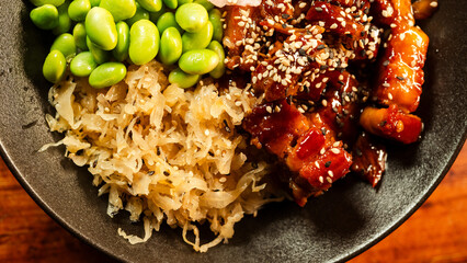 Sticky pork belly teriyaki bowl served with edamame, pickled cabbage, ginger pickle, sesame seeds, and rice. Sweet-savory glaze, vibrant colors, a complete Japanese meal.