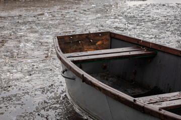 stara, drewniana łódka na skutym lodem jeziorze © Magdalena