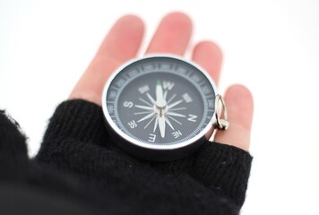 A compass in the human hand mitten in winter concept of navigation searching way season photo snowy