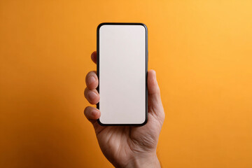A hand holding a blank smartphone against an orange background.