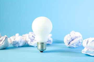 light bulb with crumpled paper on blue background