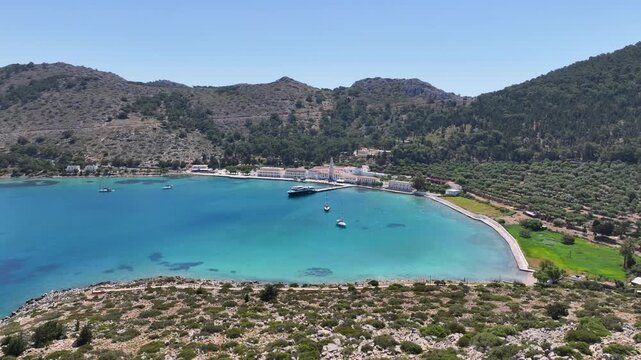 Aerial drone cinematic video of iconic bay and Monastery of Archangel Michael Panormitis, Symi island, Dodecanese, Greece