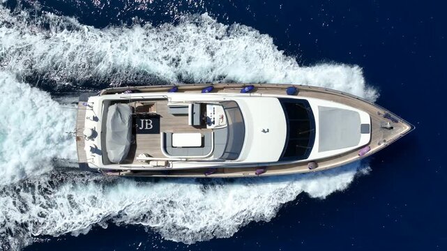 Aerial drone tracking video of luxury yacht cruising in deep blue open ocean sea