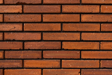 Terracotta brick wall with dark mortar joints