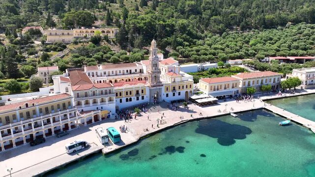 Aerial drone cinematic video of iconic bay and Monastery of Archangel Michael Panormitis, Symi island, Dodecanese, Greece