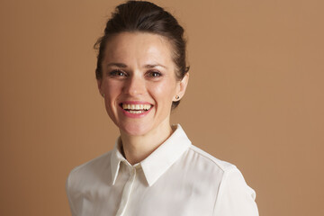 A close-up portrait of a mid-adult woman with a warm, broad smile, perfect for conveying professionalism, approachability, and successful leadership in a corporate setting.