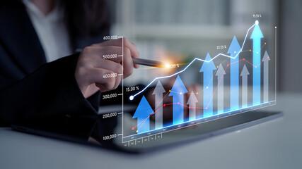 A business analyst engaging with a digital graph on a tablet to showcase financial growth trends, demonstrating innovation and modern technology in a professional setting. Scalp