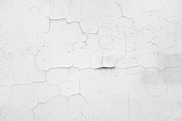 Texture of severely cracked and peeling white paint on an aged wall surface