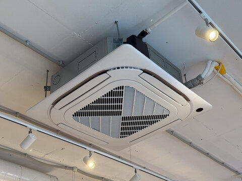 Ceiling mounted air conditioning unit in a modern commercial interior. Climate control, ventilation, and energy efficient building system