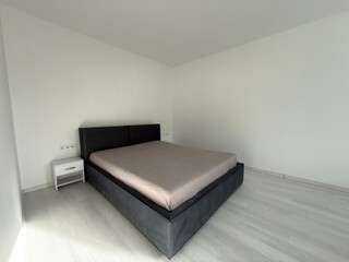 Minimalist modern bedroom with large bed and clean white walls