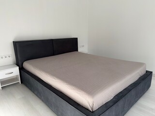 Minimalist modern bedroom with large bed and clean white walls