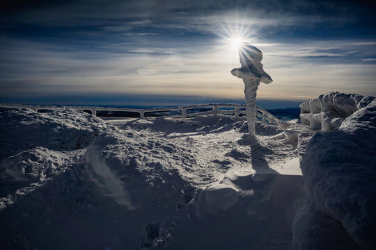 Frozen winter morning on Halicz peak in the Bieszczady Mountains. Snow-covered ridges, icy summit cross and clear sky along the popular Tarnica Halicz Rozsypaniec hiking loop.
