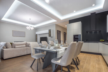 Fototapeta premium An open living space with a modern kitchen and living room with elegant furniture and soft lighting.