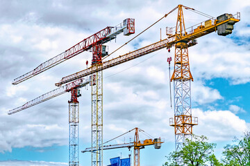 Iron construction cranes on blue sky background
