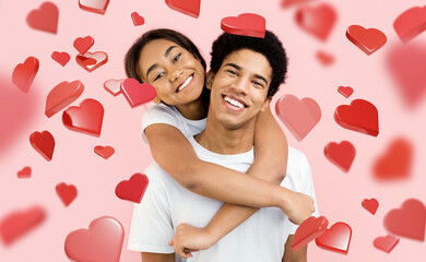 A couple enjoys their time together as the girl hugs the guy from behind, both smiling. The...