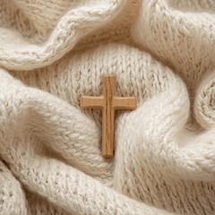 A wooden cross resting peacefully on soft knitted fabric, symbolizing faith and devotion. The image creates a sense of serenity and contemplation.