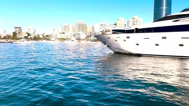 Boat-level shot showing Punta del Este&rsquo;s building line with sailboats in the foreground and warm sunset light