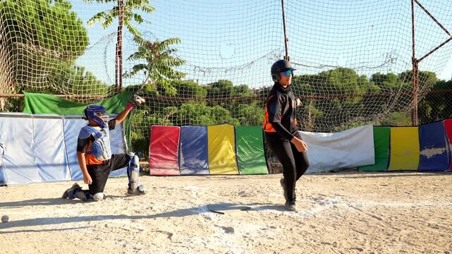 Baseball batter hitting ball and running to first base