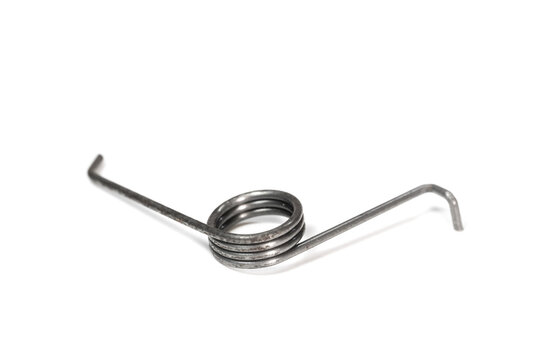 Selective focus of small metal Torsion spring on white background.