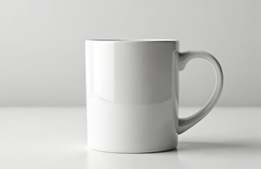 Obraz premium Plain white mug rests on white surface. Clean ceramic container with handle is perfect for branding or cafe promotions. Ideal for hot beverages.