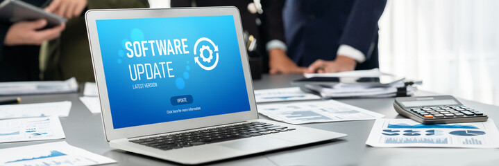 Panorama shot analyst team utilizing BI Fintech to analyze financial report with laptop. Businesspeople analyzing BI data dashboard displayed on laptop screen for business insight. Prodigy