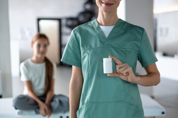 Healthcare professional showing medication container during pediatric visit