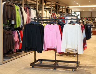 Clothing selection in a retail store with sweaters on racks, offering fashion and apparel choices for shoppers