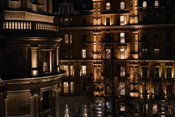 London building facades illuminating the night, showcasing elegant classical architecture and urban...