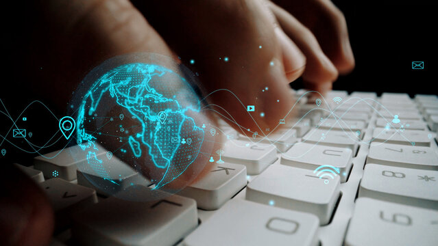A close-up view of hands typing on a keyboard, enhanced with a glowing digital globe overlay, symbolizing global connectivity and the influence of technology in everyday life. Xenic - Powered by Adobe