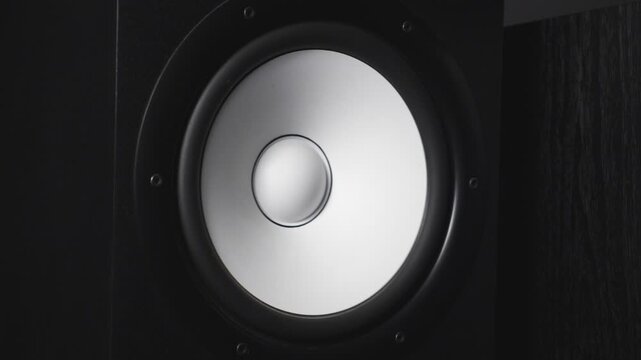 Close up of moving modern sub-woofer on recording studio. White round audio speaker pulsating and vibrating from sound on low frequency. Work of high fidelity loudspeaker membrane. Slow motion