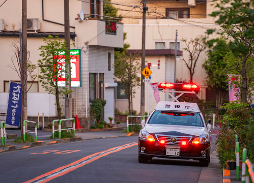 tokyo, komagome &ndash; april 11, 2025: A Japanese police car bearing the inscription "keishicho", meaning "Tokyo Metropolitan Police Department", stopped with its flashing lights deployed on the roof.