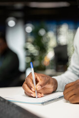 Close up of business staff taking notes to create a new strategy and fulfill goals in a dark office at night, writing data insights to forecast a global expansion. Motivation for efficiency.