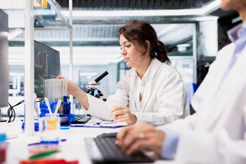 Laboratory technician using scientific gear at workbench, doing complex experiments. High tech lab employee doing genetics study using clinical equipment, doing controlled analysis