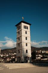 Obraz premium Tall stone bell tower rising above Andricgrad in Visegrad, Bosnia and Herzegovina. Vertical structure represents tradition, religion, and historical continuity.