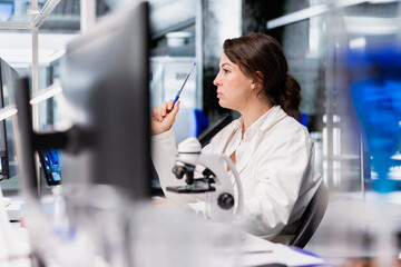 Quality control analyst using scientific gear at workbench, doing complex experiments. High tech lab worker doing genetics study using clinical equipment, checking analysis results on PC