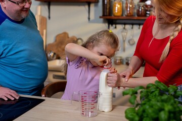 Children learn with family assistance, Casual family baking scene with guidance, Cozy family moment where children pour milk under watchful parental supervision during baking