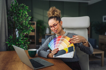 Woman designer presenting color palette on video call at home