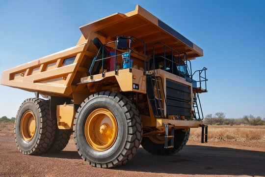 Huge Yellow Diamond Mining Dump Truck driving on Dirt Road, at an open pit diamond mine