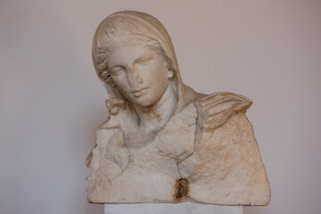 Ancient sculpture fragment of a female face. Stone texture, classical art