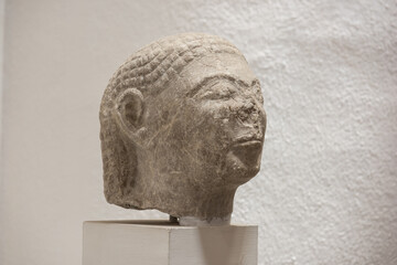 Ancient sculpture fragment of a female face. Stone texture, classical art