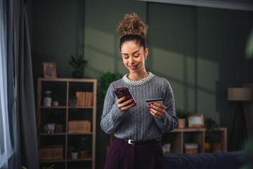 Woman buying online using mobile phone and credit card