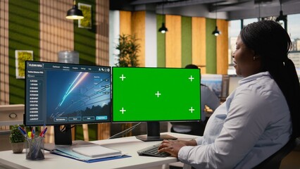 Engineer in office using electrical grid infrastructure data on green screen PC to do energy audits. RD department experts looks at transmission tower analytics on chroma key computer, camera A