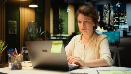 Corporate manager proofreading a presentation and planning objectives for company, solving tasks after hours in the dark office. Executive insight focused on budgeting and targets. Camera A.