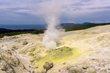 Geysers release steam in remote Russian landscape under cloudy skies